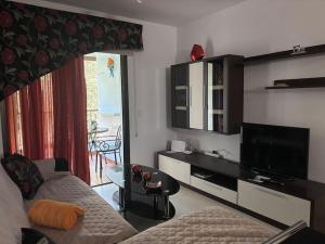 a living room with a couch and a flat screen tv at Puesta de Sol in Punta del Hidalgo