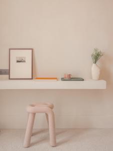 a pink stool in front of a white shelf at Hôtel Liautaud Rooftop Cassis in Cassis