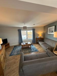 una sala de estar con un sofá y una mesa en Church walk view apartment Filey, en Filey