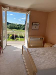 a bedroom with a bed and a large sliding glass door at Belle Maison avec vue magnifique , séjour pleine nature gd jardin in Cressat
