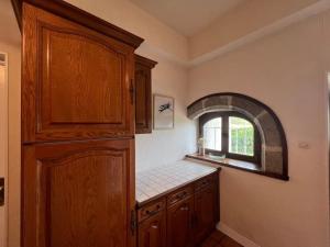 a kitchen with a large wooden cabinet and a window at Belle Maison avec vue magnifique , séjour pleine nature gd jardin in Cressat +18 photos