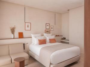 a bedroom with a white bed and a couch at Hôtel Liautaud Rooftop Cassis in Cassis