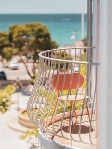 a wire basket with a chair sitting on a window at Hôtel Liautaud Rooftop Cassis in Cassis