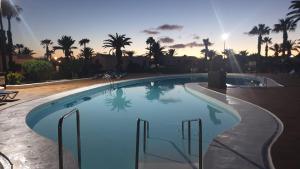 een groot zwembad met een zonsondergang op de achtergrond bij Casa Tanja Casas del Sol in Playa Blanca