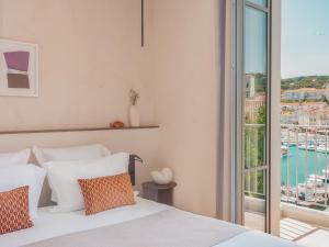 a bedroom with a bed with a view of a harbor at Hôtel Liautaud Rooftop Cassis in Cassis