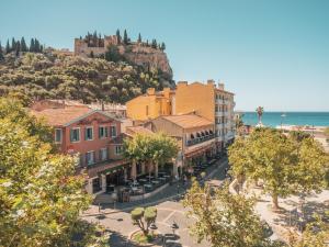 a view of a town with a castle on a hill at Hôtel Liautaud Rooftop Cassis in Cassis