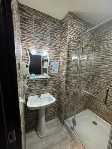 a bathroom with a sink and a shower at Pirosmani Mini Hotel in Batumi