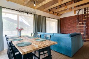 a dining room with a table and a blue couch at Chill na Skrzynce in Skrzynka Wielka