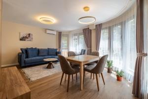 a living room with a table and a blue couch at Daya 2BR Luxury Apartment in Varna City