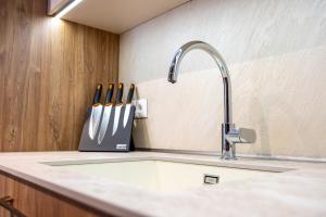 a kitchen counter with a sink and a knife block at Daya 2BR Luxury Apartment in Varna City +52 photos