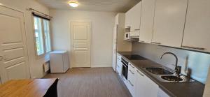 a kitchen with white cabinets and a sink at Pohjankatu 18B 2 - Vanha Rauma in Rauma