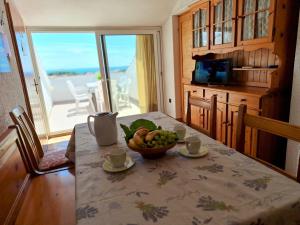 a dining room table with a bowl of fruit on it at Loft Apartman in Krk