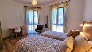 a bedroom with two beds and a desk and windows at Casa Pirusa in Barlovento +27 photos