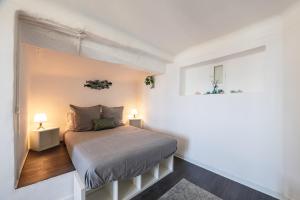 a small bedroom with a bed and two lamps at Le plaisir des yeux ! in Cassis