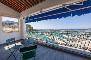 a balcony with a table and chairs and a view of the ocean at Le plaisir des yeux ! in Cassis