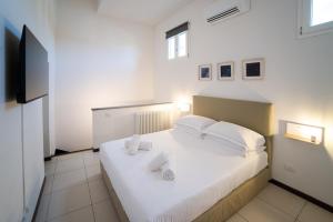 a bedroom with a bed with white sheets and a flat screen tv at Coco Places Apartments Santa Maria Novella, Centro Storico in Florence