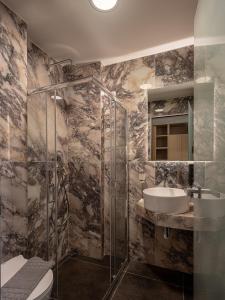 a bathroom with a sink and a shower and a toilet at Miss Marrone City Hotel in Chania Town