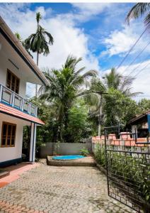 a house with a swimming pool and palm trees at Chills homestay in Kalpetta