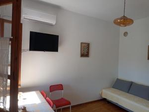a living room with a couch and a tv on a wall at Katerina's apartment in Keramídhion