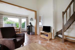 a living room with a couch and a television at Ferienhaus Drybarg in Simonsberg