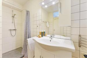 a white bathroom with a sink and a shower at Haringvliet 011 - Noordzeepark Ouddorp NOT INTENDED FOR COMPANY OR WORK-RELATED STAYS in Ouddorp +25 photos