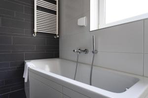 a bath tub in a bathroom with a mirror at Mosselbank 073 - Noordzeepark Ouddorp in Ouddorp +54 photos