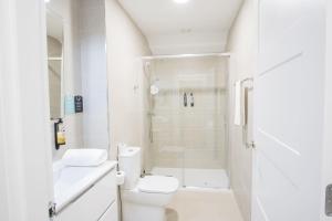 a white bathroom with a shower and a toilet at Hotel Alda Triacastela in Tríacastela +77 photos