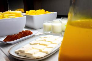 a table with a plate of cheese and other foods at Acta The Clover in Porto