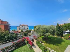 a view of a garden with flowers and the ocean at Bell'alloggio a due passi dalle spiagge di Riva Ligure in Riva Ligure