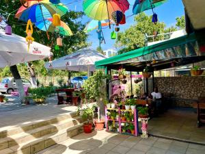 a store with umbrellas and plants on a street at First Sea Line Apartment FLORA, next to the beach in Pomorie