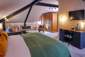 a room with a bed and a couch and a tv at Hotel Du Vin & Bistro York in York