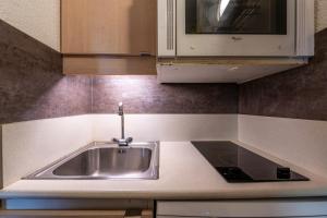 una cocina con fregadero y microondas en Appartement 4p, en Méribel 13 fotos más