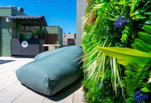 a large green pillow sitting on a patio with plants at Acta The Clover in Porto