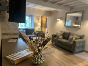 a living room with a vase of flowers on a table at Posh Little Cottage in Llangollen