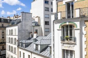 a view of the roofs of buildings in a city at Villa des Ambassadeurs in Paris