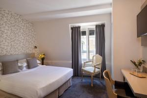 a hotel room with a bed and a desk at Villa des Ambassadeurs in Paris +60 photos
