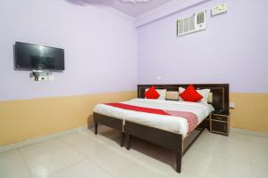 une chambre avec un lit avec des oreillers rouges et une télévision dans l'établissement Hotel O Sunrise Inn, à Indirapuram 42 autres photos