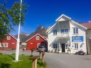a group of buildings with mountains in the background at Anker Brygge in Svolv&aelig;r