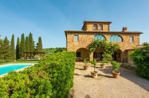 an old stone house with a swimming pool and plants at Villa Gagnoni in Sinalunga