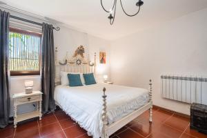 a bedroom with a white bed and a window at Casa Museu da Geada - Rural Hotel in Cinfães