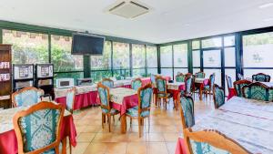 a restaurant with tables and chairs and a flat screen tv at Hotel Pizarro in Humanes de Madrid