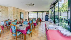 a dining room with tables and chairs with pink and blue at Hotel Pizarro in Humanes de Madrid