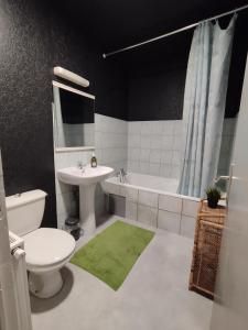a bathroom with a sink and a toilet and a tub at Gites Le Roosevelt - Côte 204 in Château-Thierry