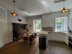 a kitchen with a table and a dining room at Little Bay View in Oban