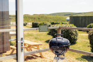 a black grill sitting on top of a fence at West Chalet At Tapnell Farm in Yarmouth +29 photos