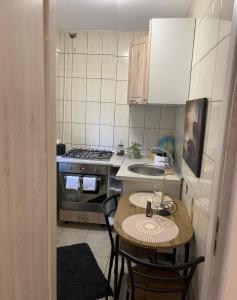 a small kitchen with a table and a stove at Apartament de lux in Craiova