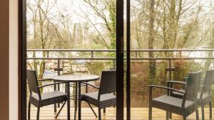 a balcony with chairs and a table and a window at 2 Bedroom Lake District Cottage At Windermere Marina Village in Bowness-on-Windermere