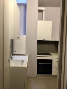 a small kitchen with white cabinets and a sink at Casa Cerasoli Gallipoli in Gallipoli