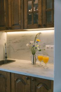 a kitchen counter with two glasses of orange juice and flowers at Vila Šilelis in Palanga +18 photos