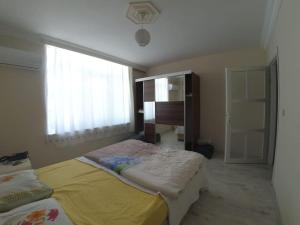 een slaapkamer met twee bedden en een groot raam bij MCKızılsaray Apart in Antalya